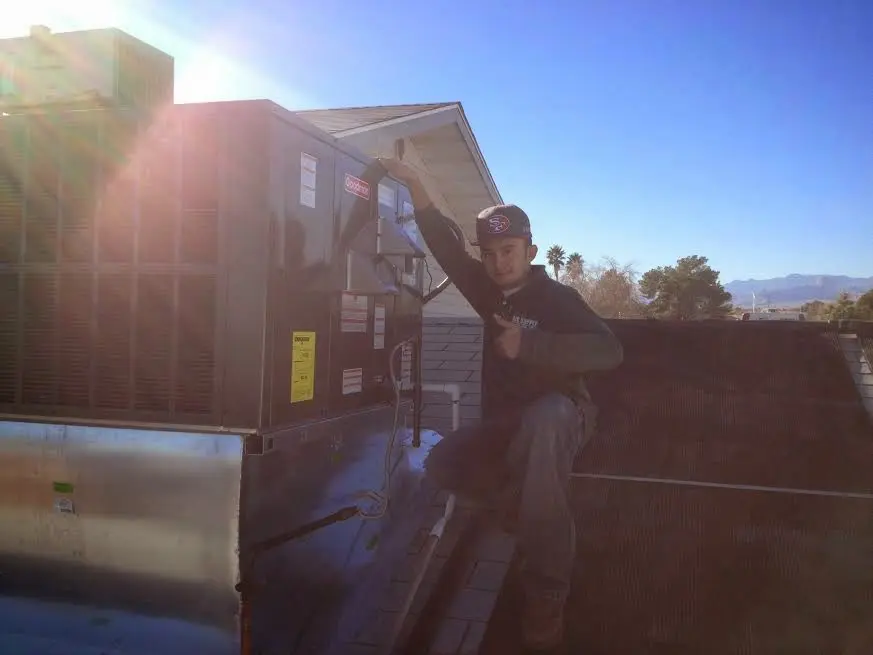 HVAC technician performing AC Tune-Up on a rooftop unit in Olympia